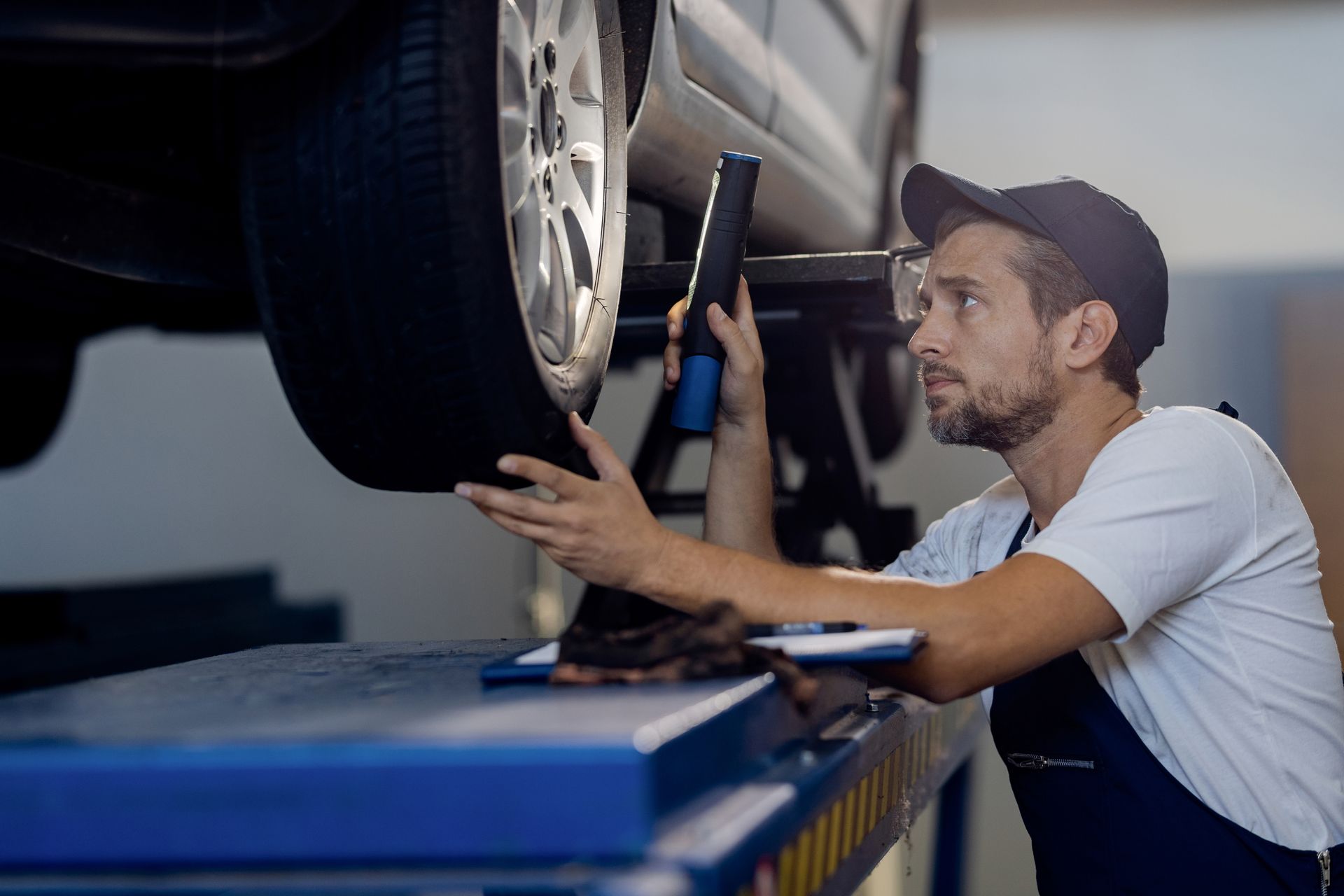 Un hombre está trabajando en un neumático de automóvil en un garaje.