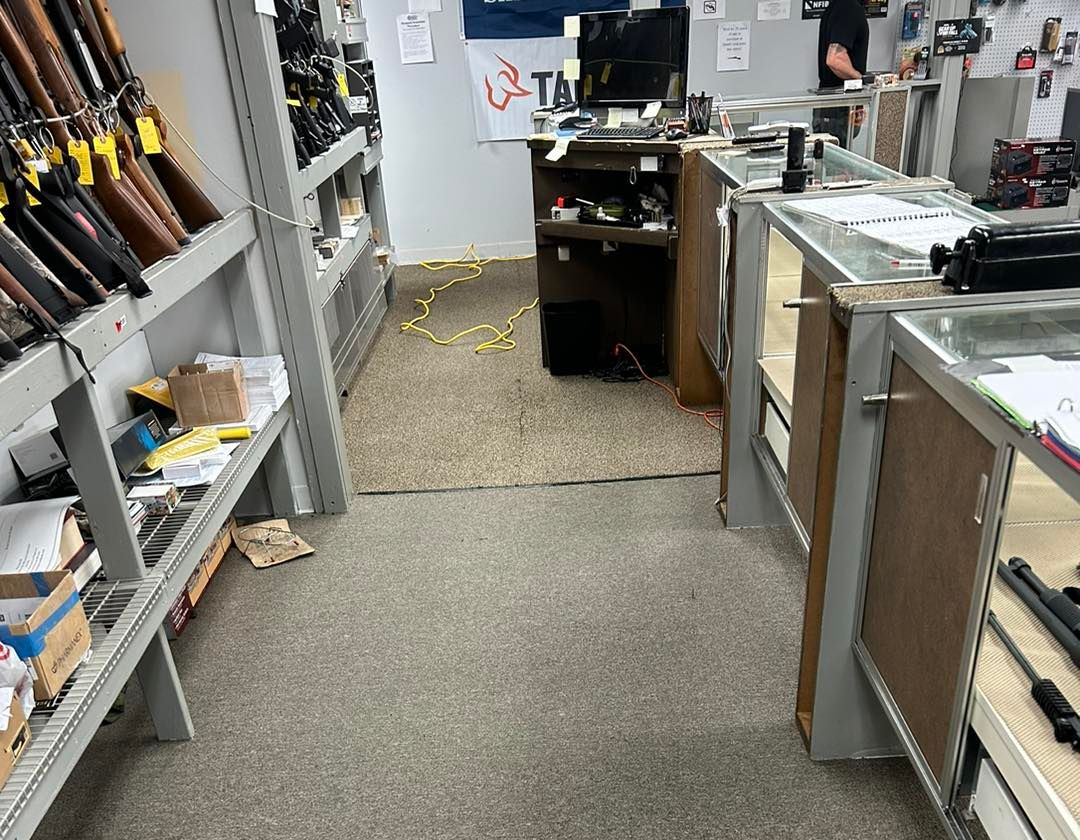 Gun store interior with long aisles, displays, and firearms.