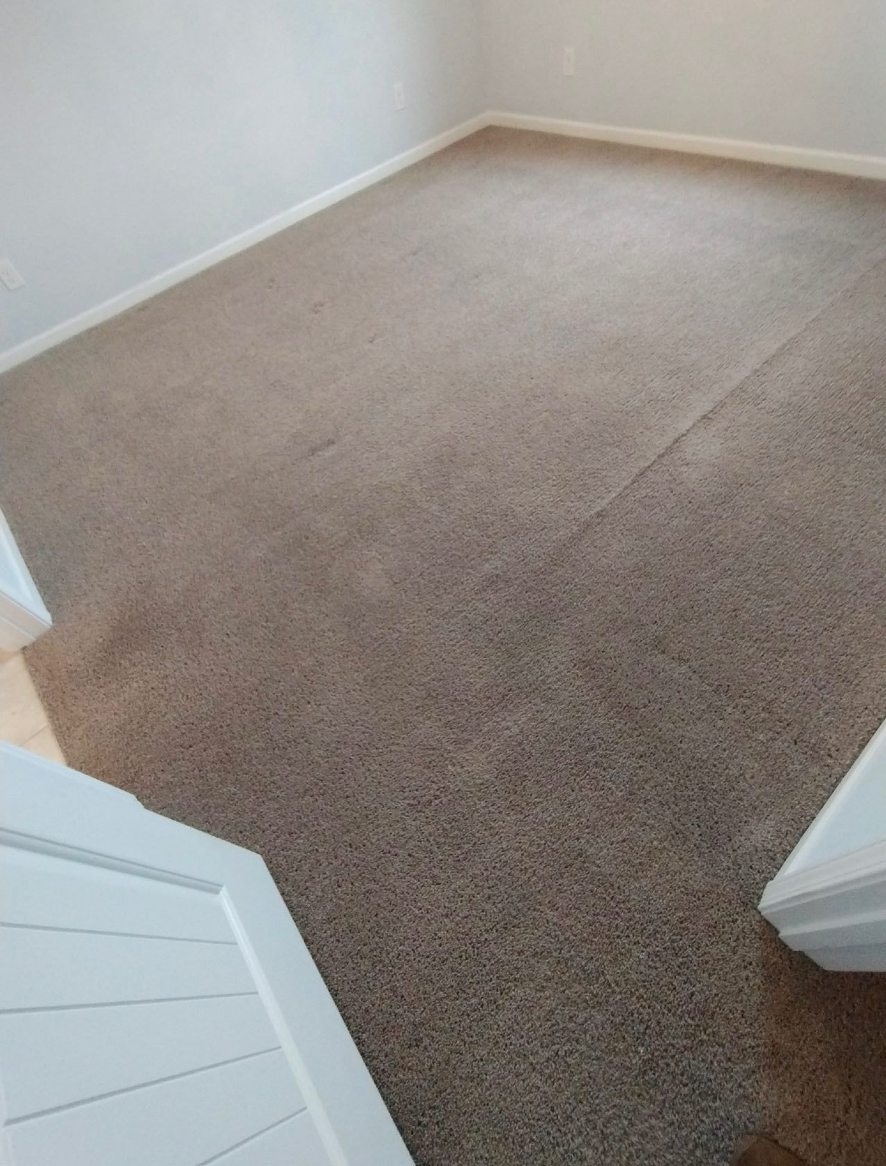 Beige carpet in a room with white trim and doors.
