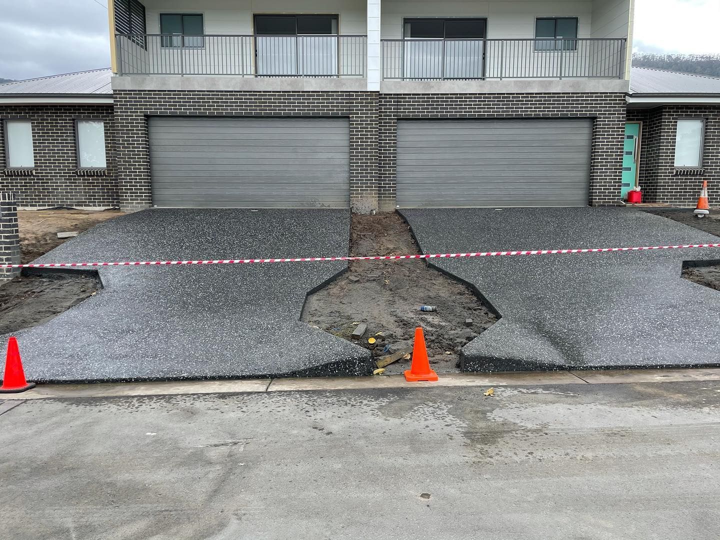 A Two-story Building Under Construction With Two Garages and Aggregate Concrete Driveways — JDB Concreting in Horsley, NSW