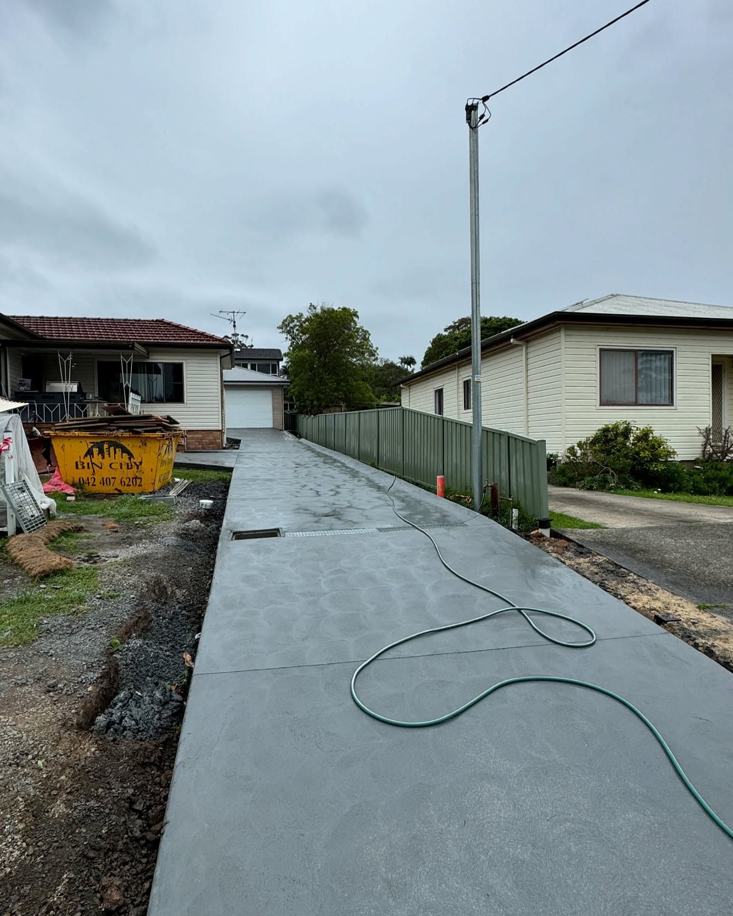 A Newly Poured Concrete Driveway Leads Between Two Residential Houses — JDB Concreting in Southern Highlands, NSW