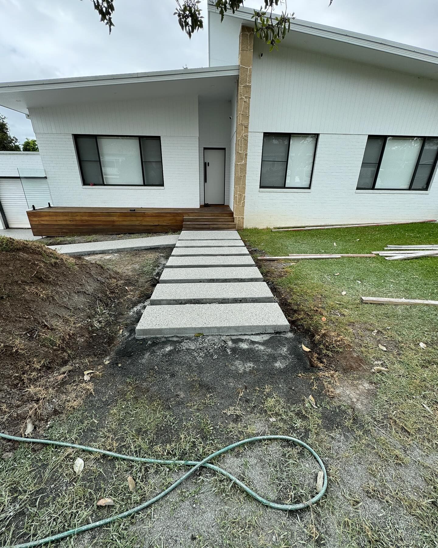 A White Modern House With a Stone Entryway — JDB Concreting in Horsley, NSW
