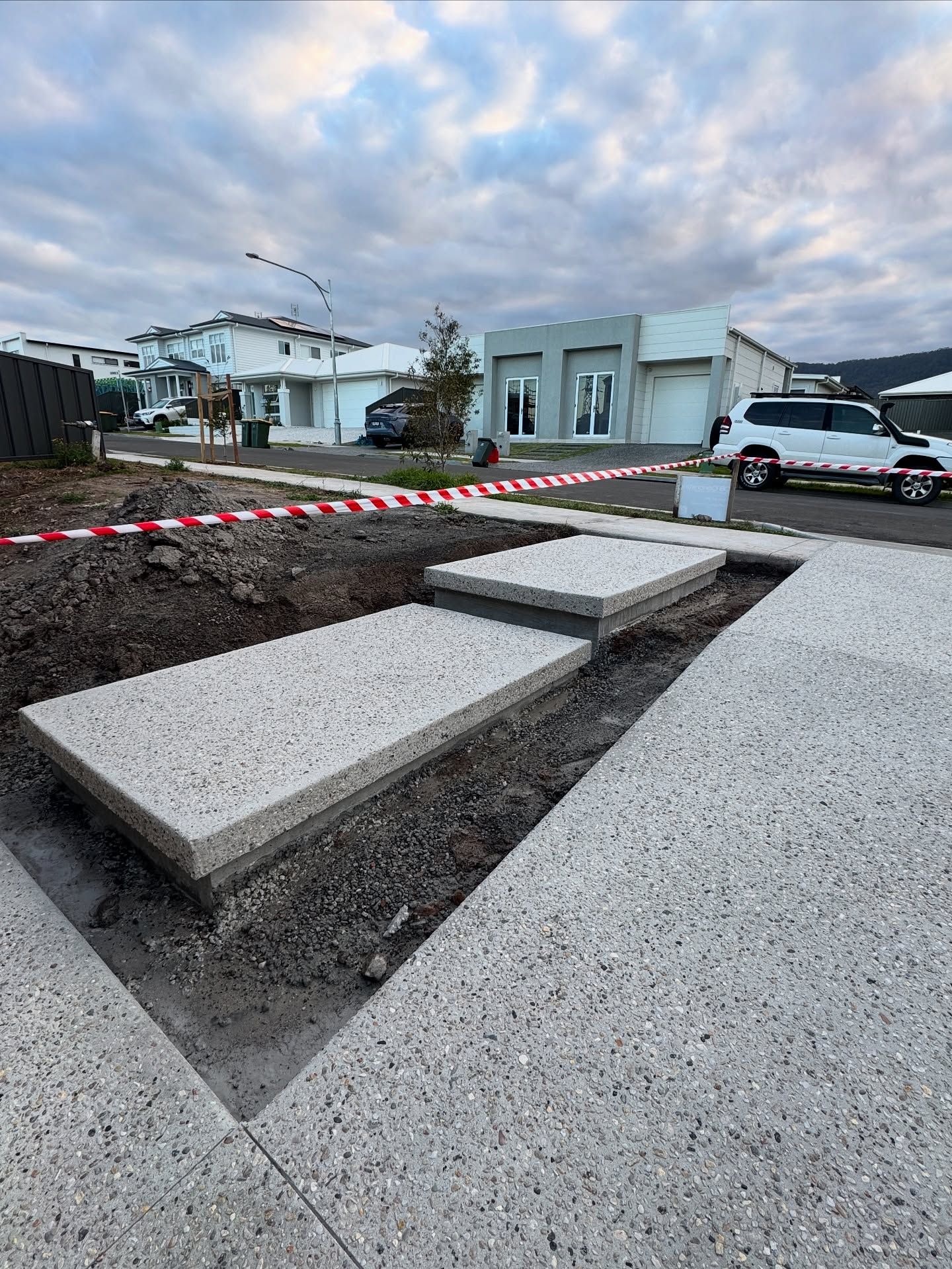 Two Concrete Steps Set Into a Dirt Patch, Leading From a Textured Sidewalk — JDB Concreting in Dapto, NSW