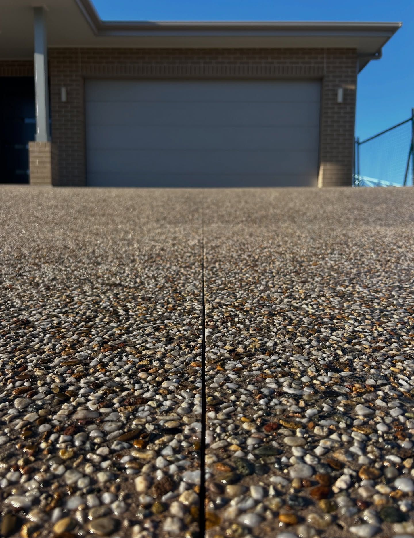 A Low-angle View of an Exposed Aggregate Concrete Driveway — JDB Concreting in Thirroul, NSW