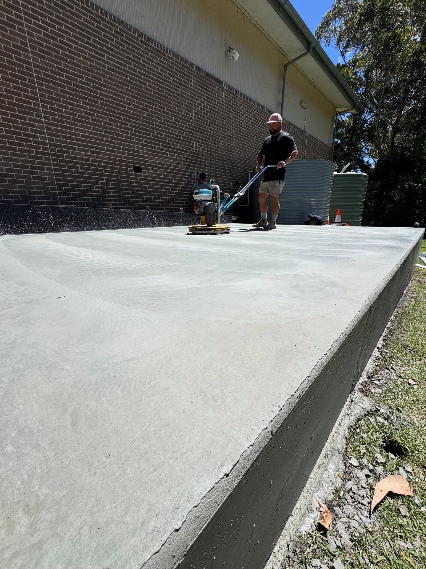 A Worker Uses a Concrete Finishing Power Trowel on a Newly Poured Patio Slab — JDB Concreting in Horsley, NSW
