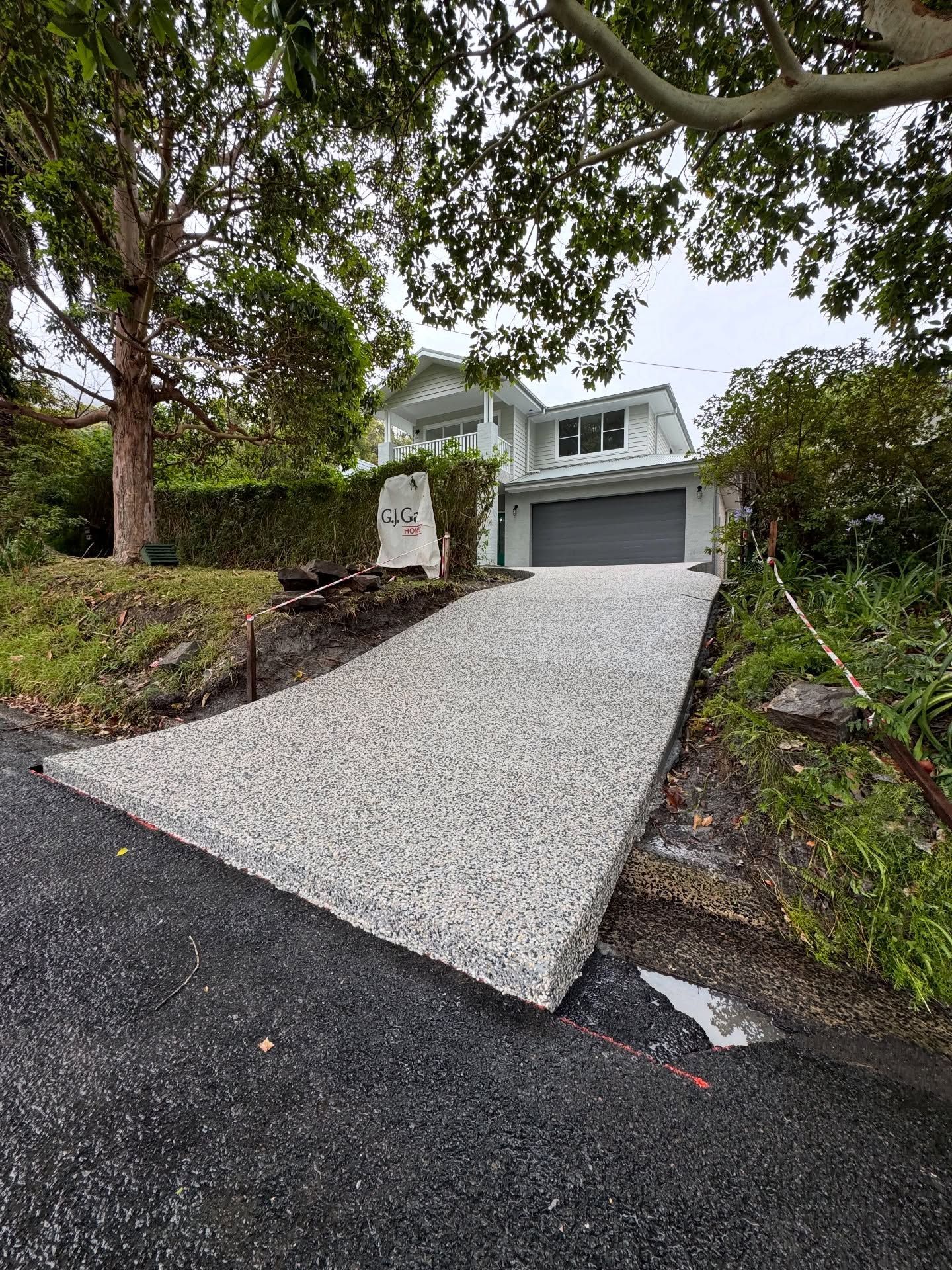 A Newly Paved, Light Grey Aggregate Driveway — JDB Concreting in Thirroul, NSW
