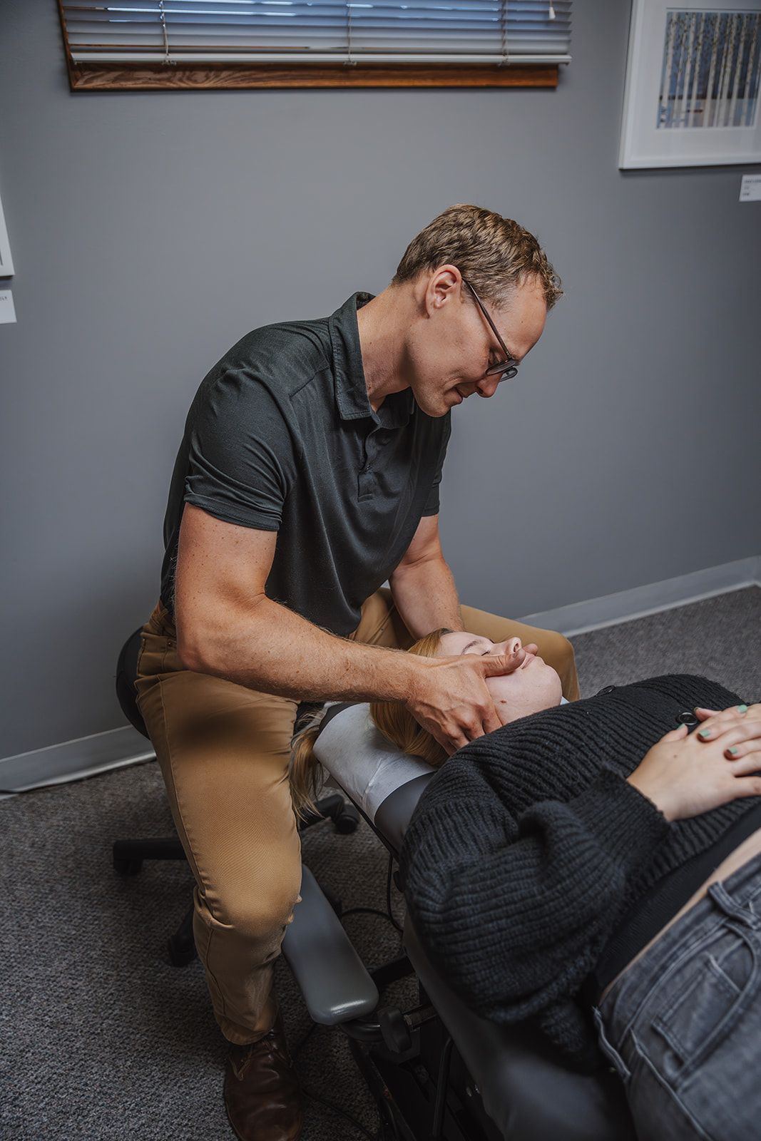A man is stretching a woman 's leg on a table.