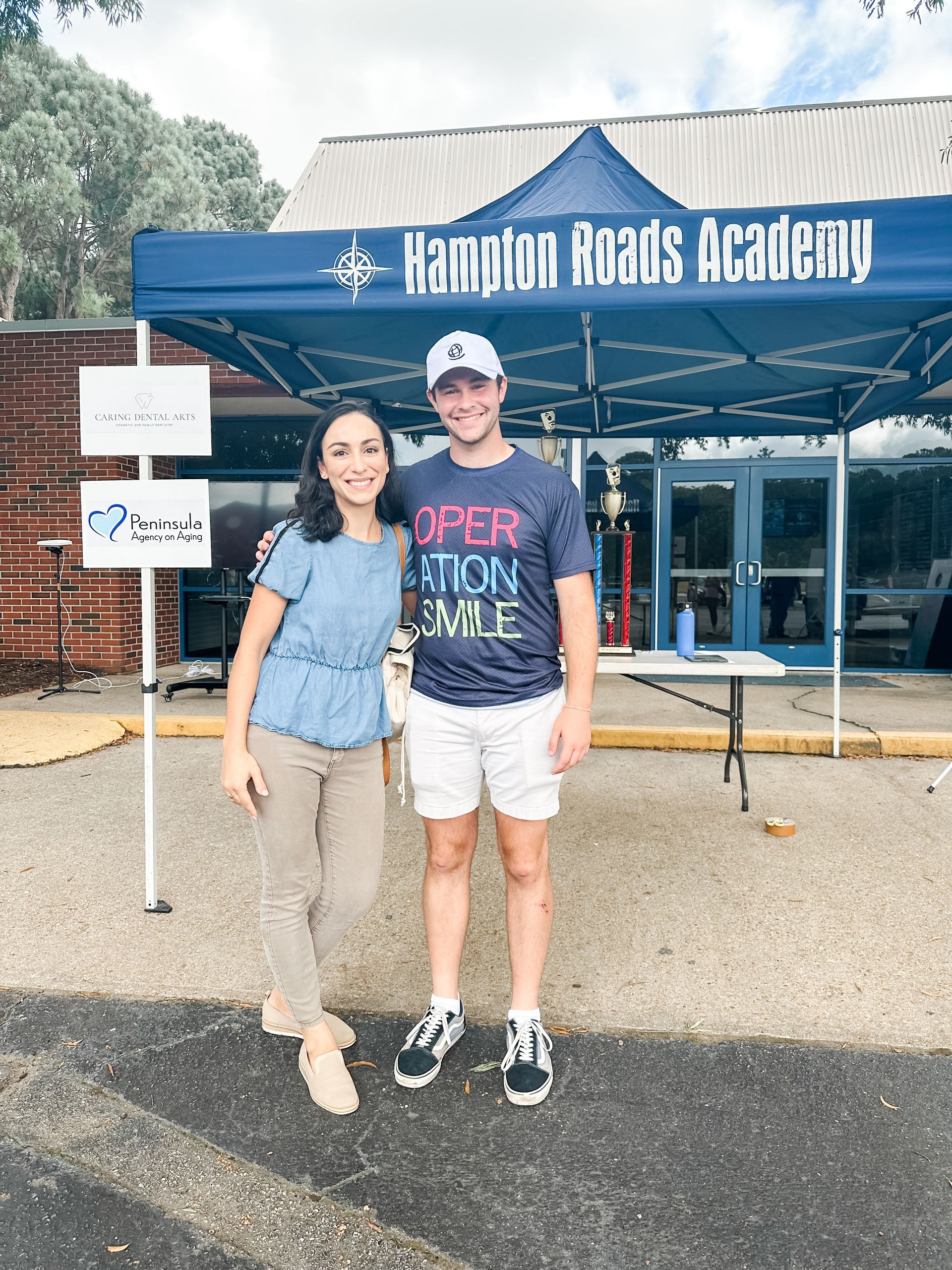 A man and a woman are posing for a picture in front of a tent.