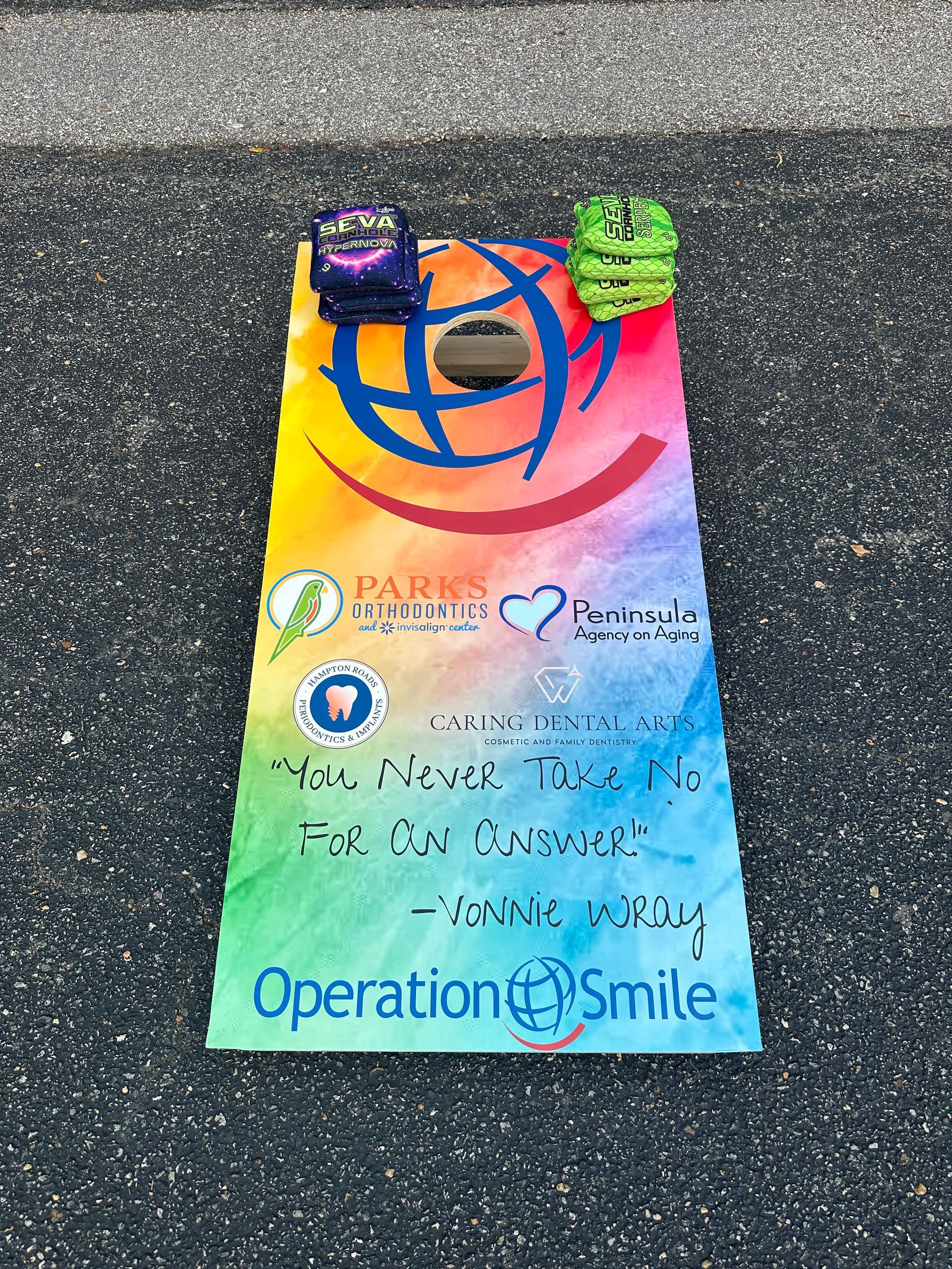 A colorful sign that says operation smile is sitting on the ground.