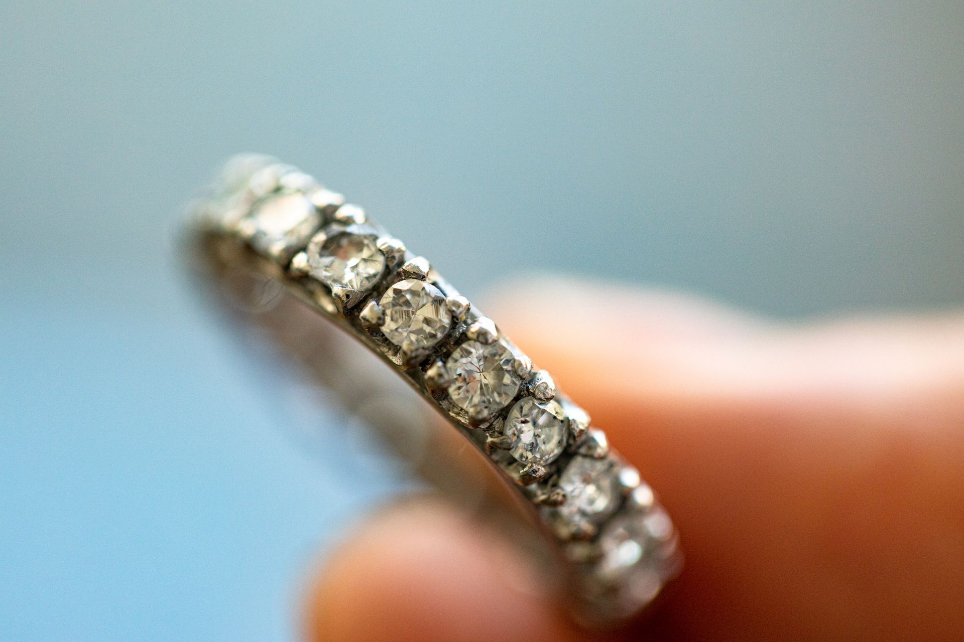 A person is holding a diamond ring in their hand
