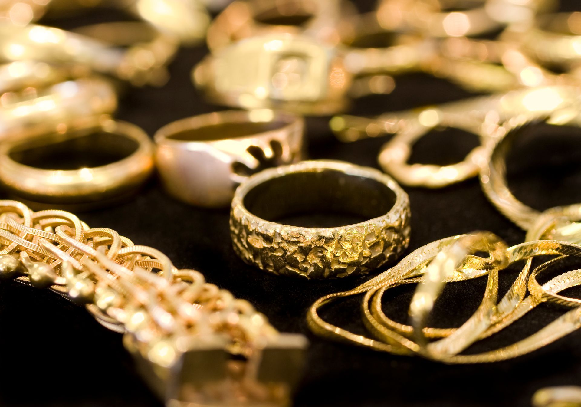 A bunch of gold rings and bracelets on a table