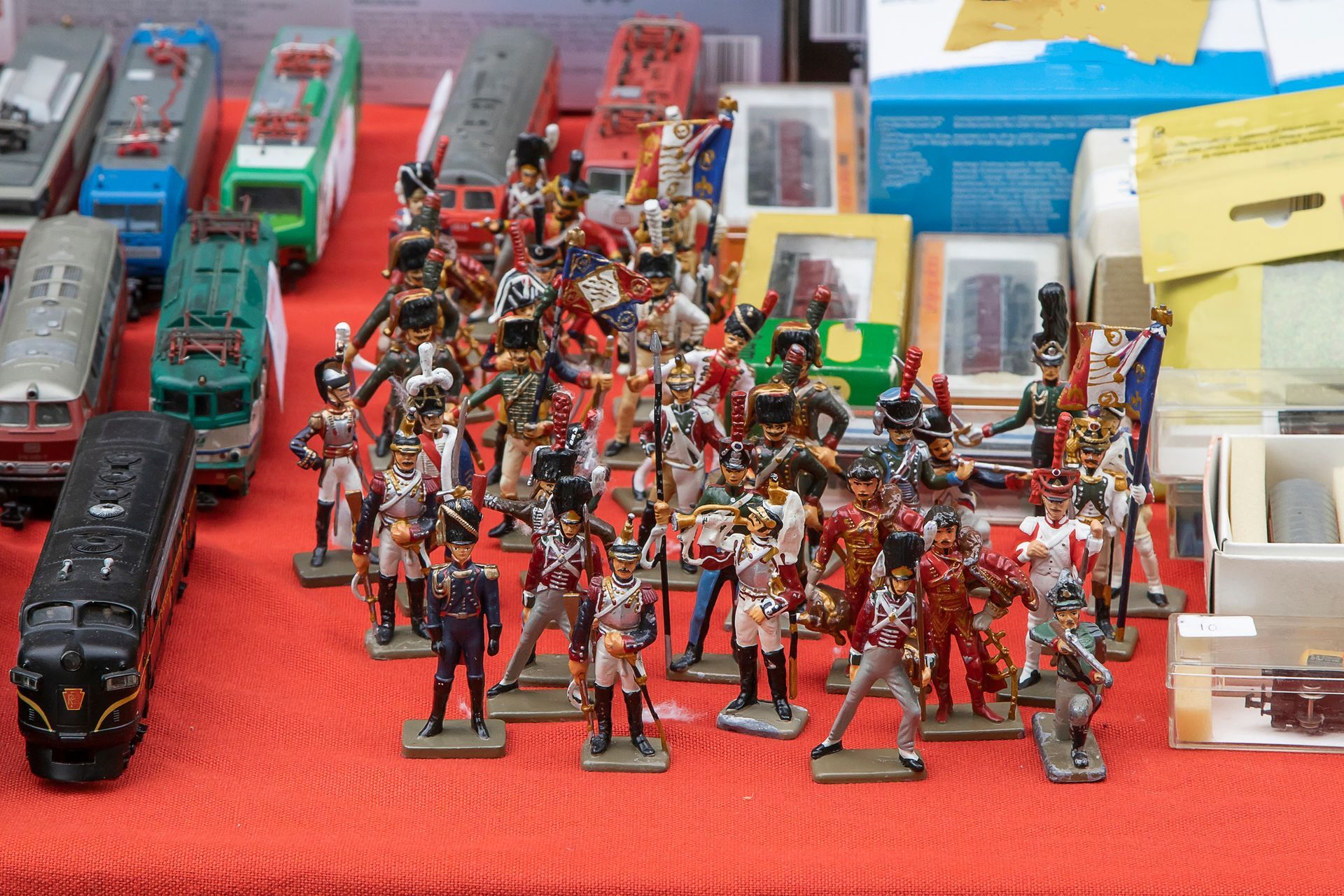 A table with a bunch of toy soldiers and trains on it