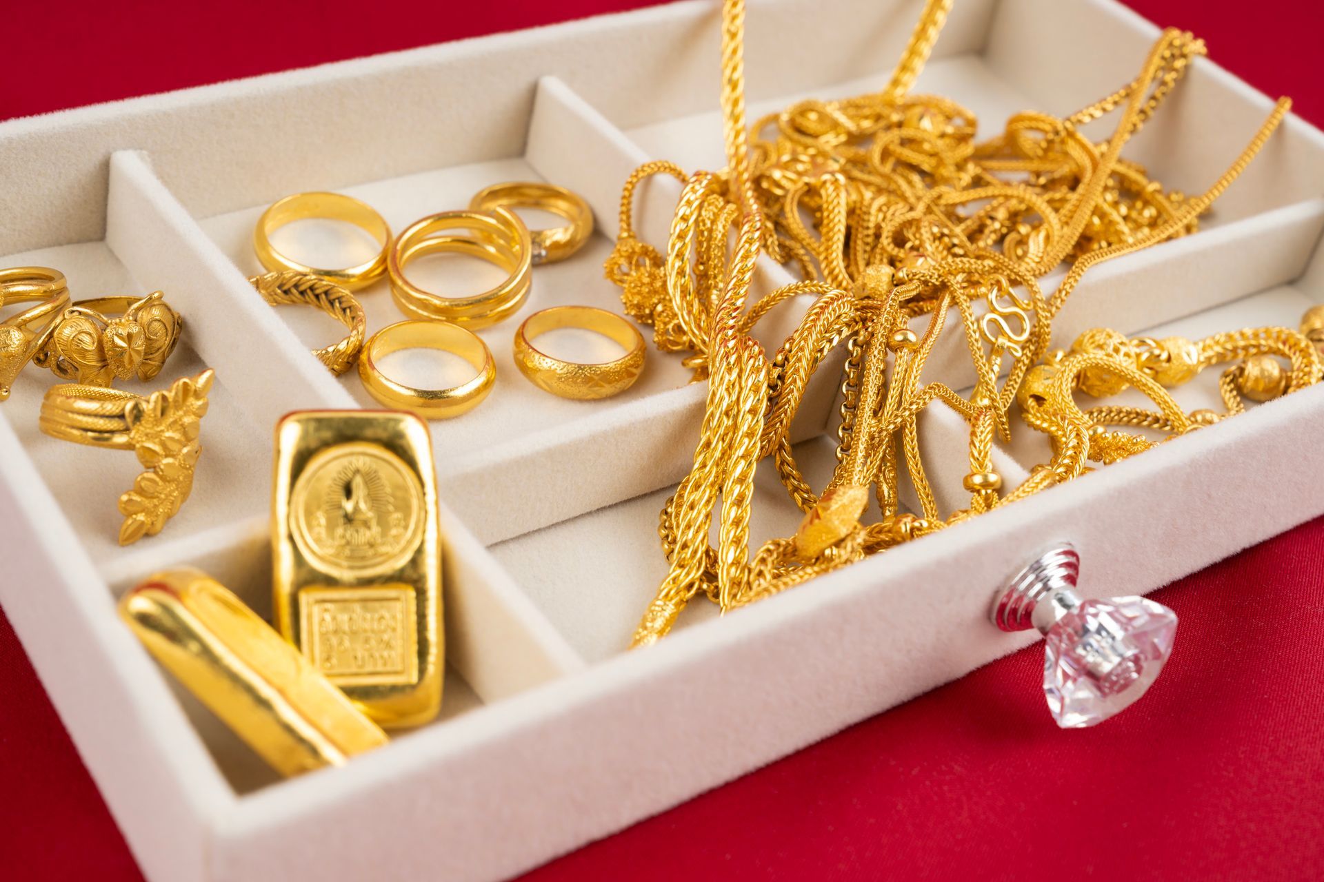 A tray filled with gold jewelry including a gold bar