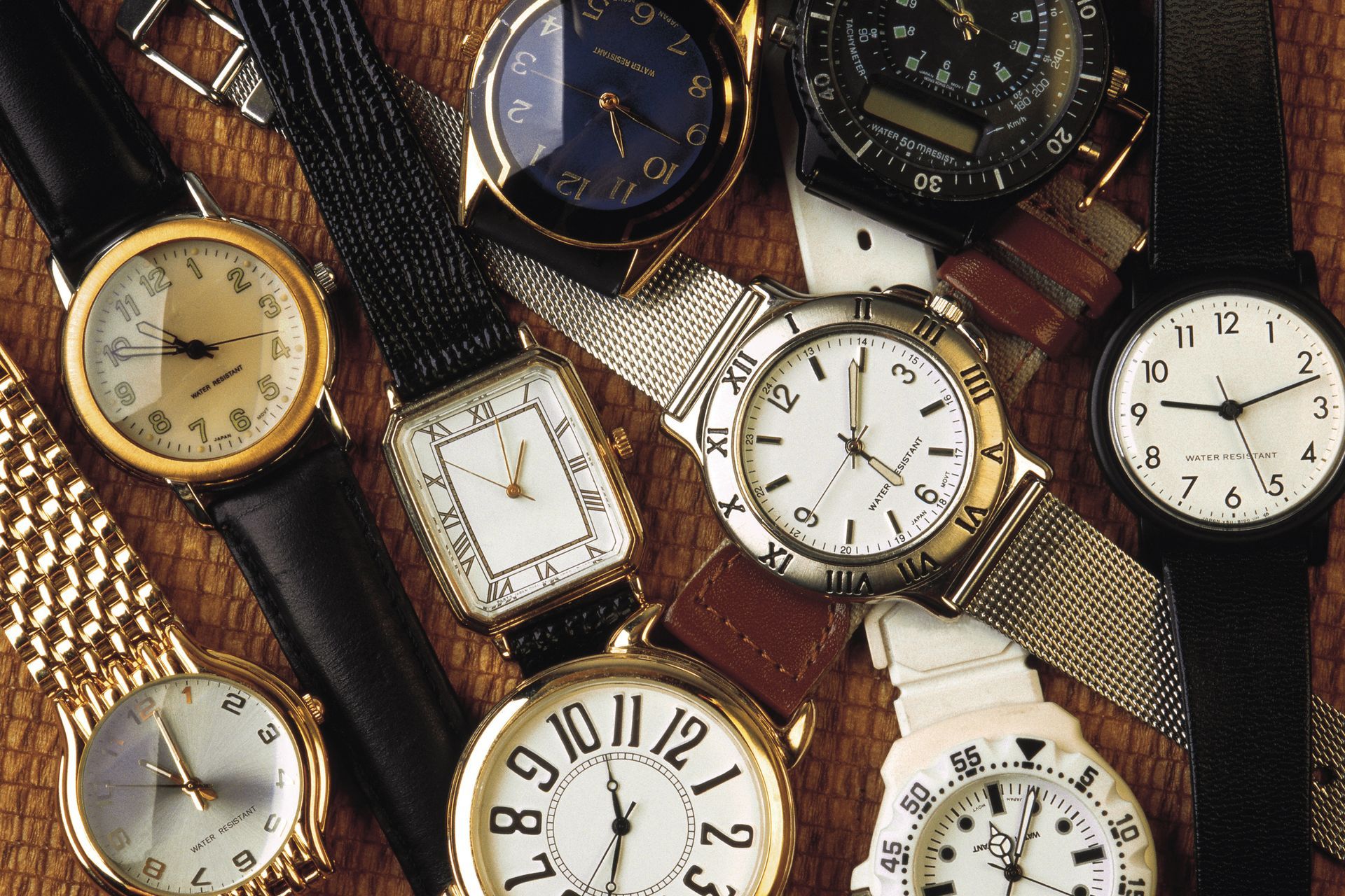 A pile of old pocket watches are stacked on top of each other.