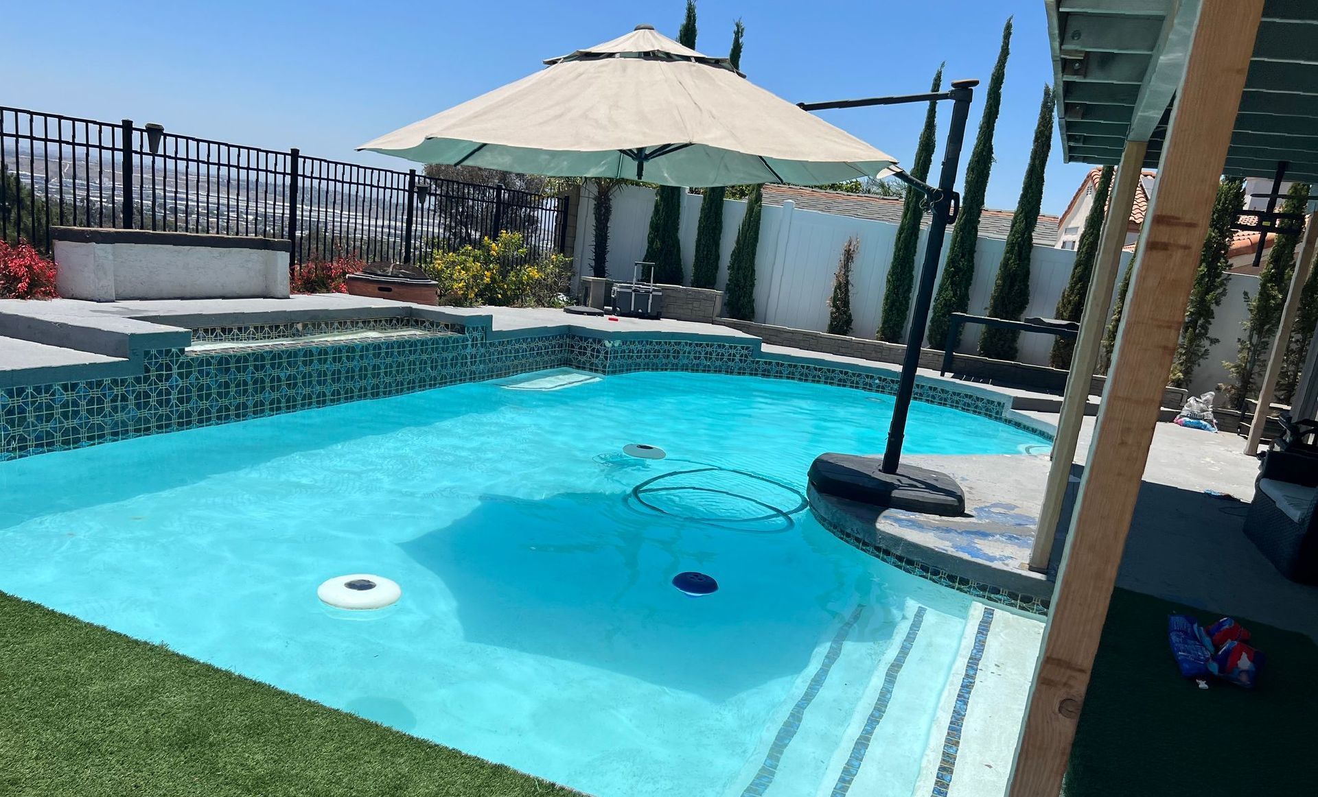 A large swimming pool with a large umbrella on top of it