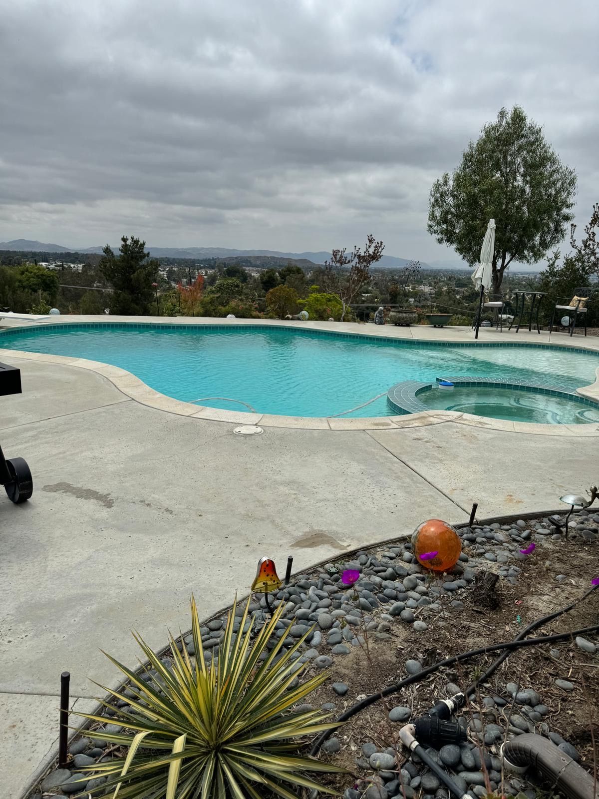 Pool overlooking a distant landscape under a cloudy sky.