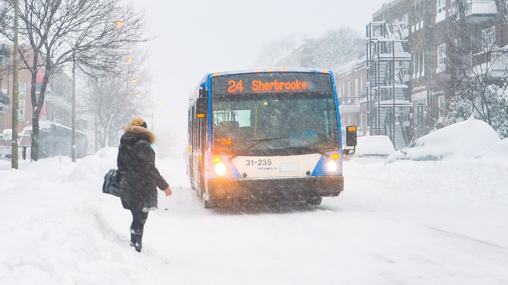 A bus is driving down a snow covered street.