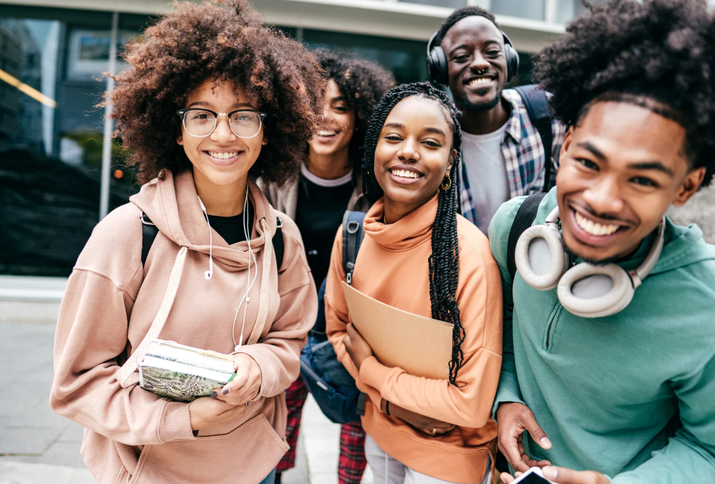 A group of young people are posing for a picture in front of a building.