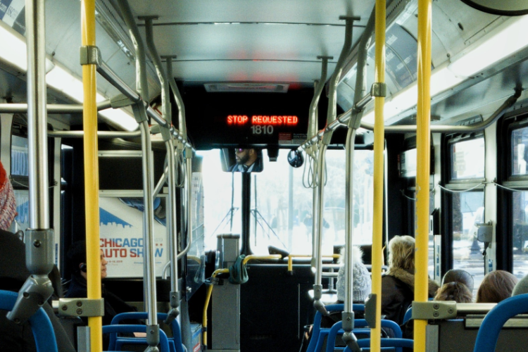 The inside of a bus with a sign that says stop waiting