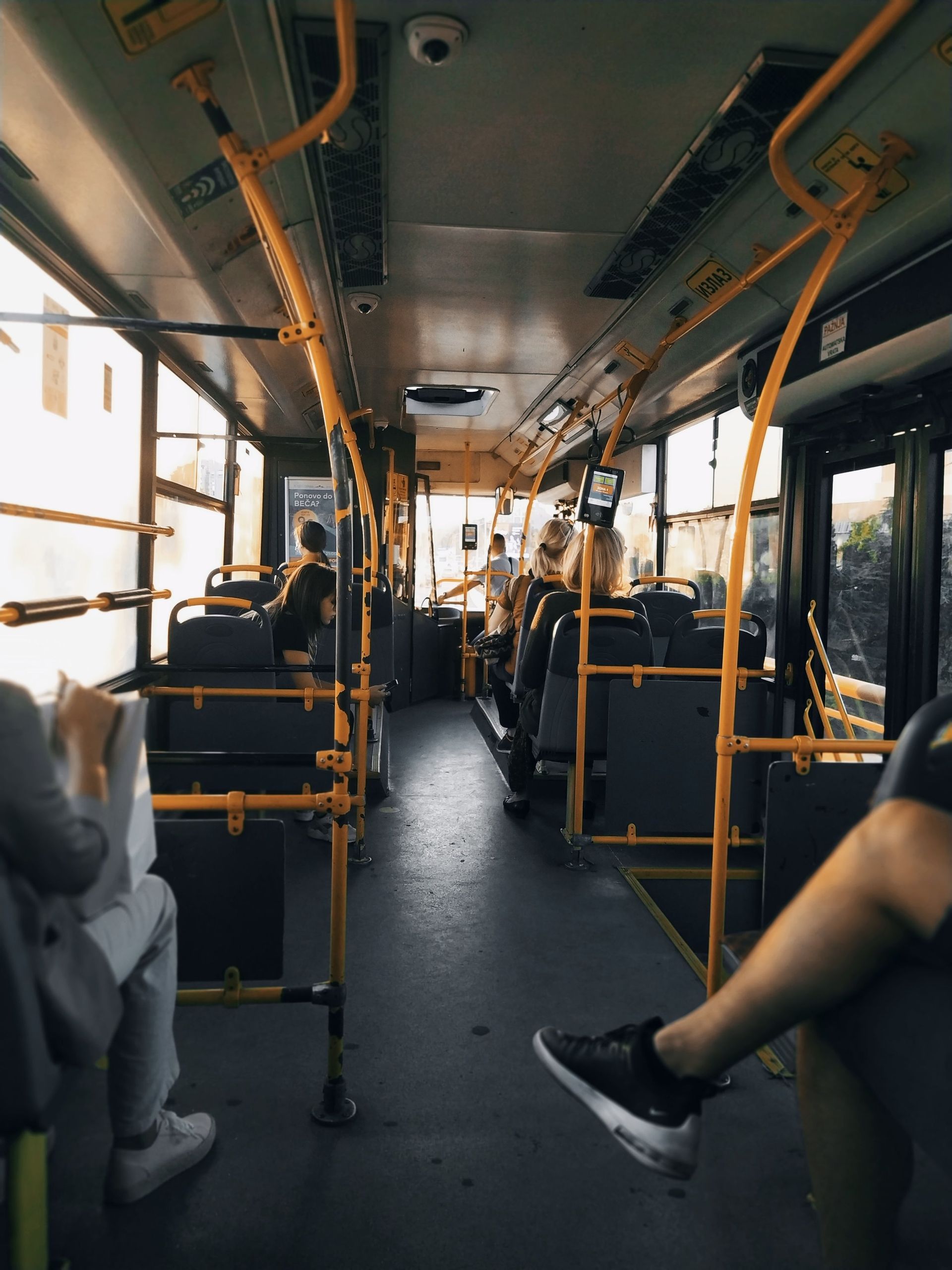 People are sitting on a bus with their legs crossed