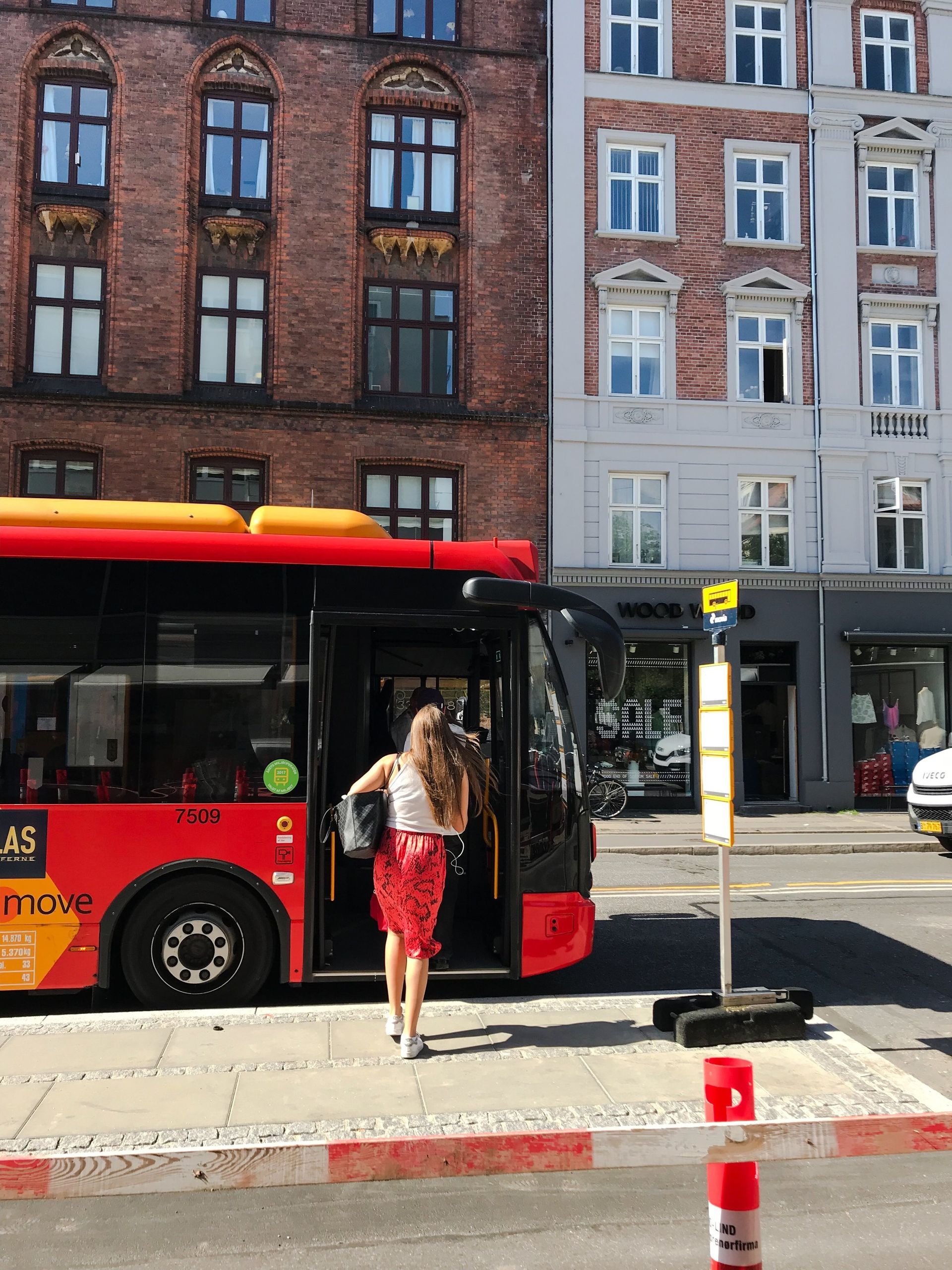 A woman is getting off a red bus that says city king