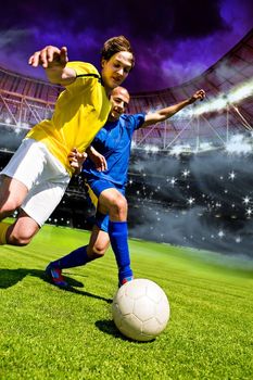 Dos jugadores de fútbol con uniformes amarillos y azules compiten por la posesión del balón en un campo de juego.