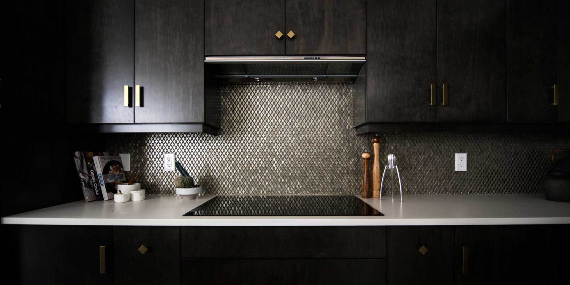 Metalic tile on this backsplash helps this kitchen to look even more luxurious .