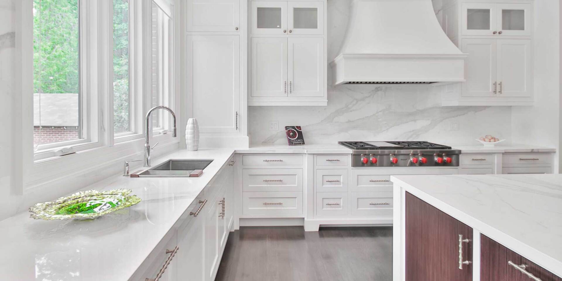 White Hamptons style kitchen with marble backsplash.