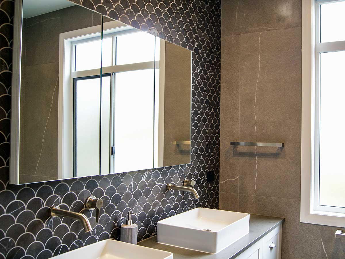 Beautiful scalloped marble look tile in a bathroom backsplash.