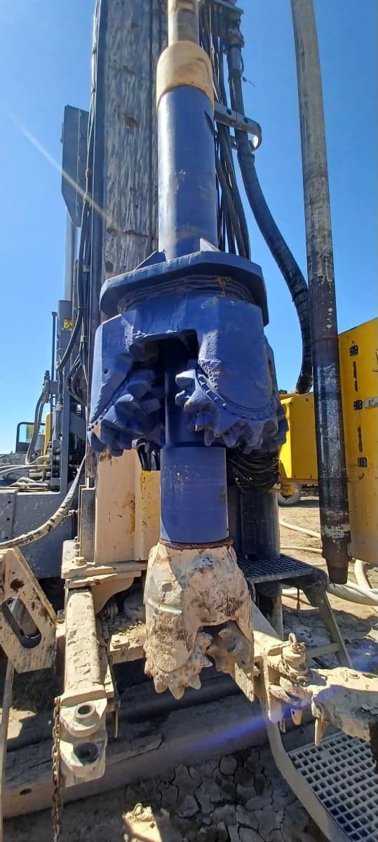 A truck is driving through a muddy field.