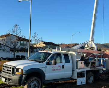 A white truck with a crane on the back of it