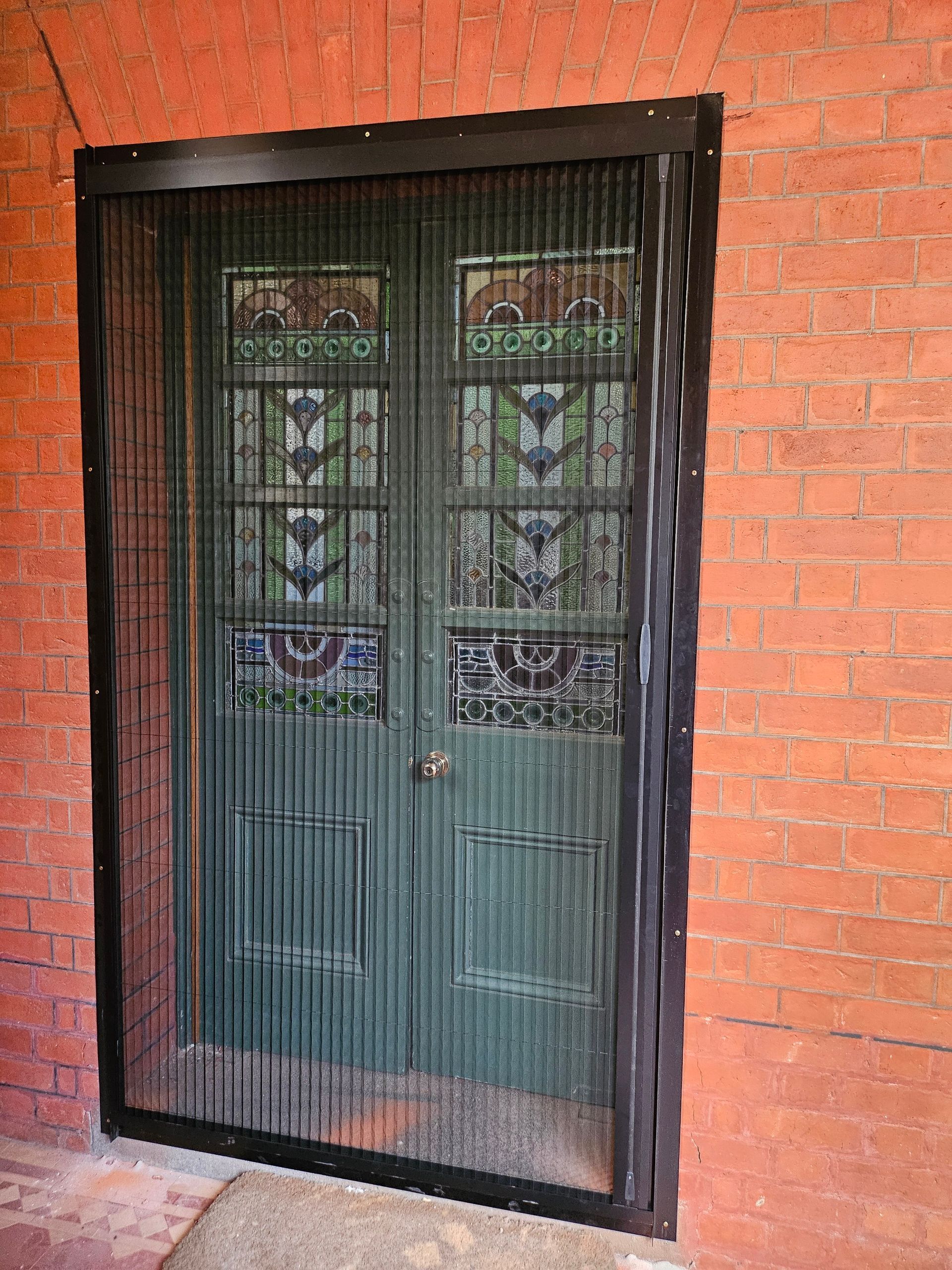 Empty room with three window shutters, ceiling fan, and dark wooden floor.