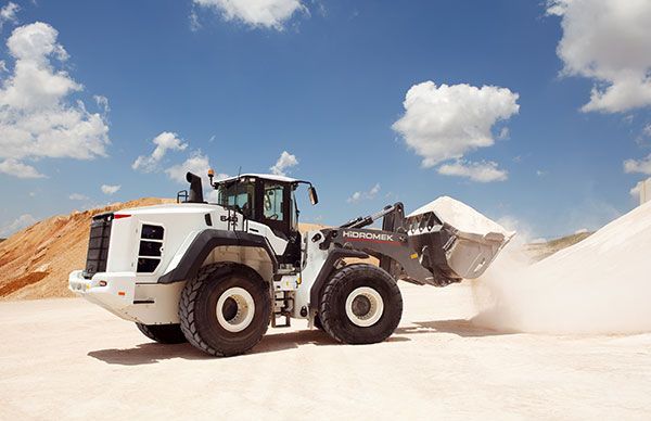 A bulldozer is loading sand into a pile in a quarry.