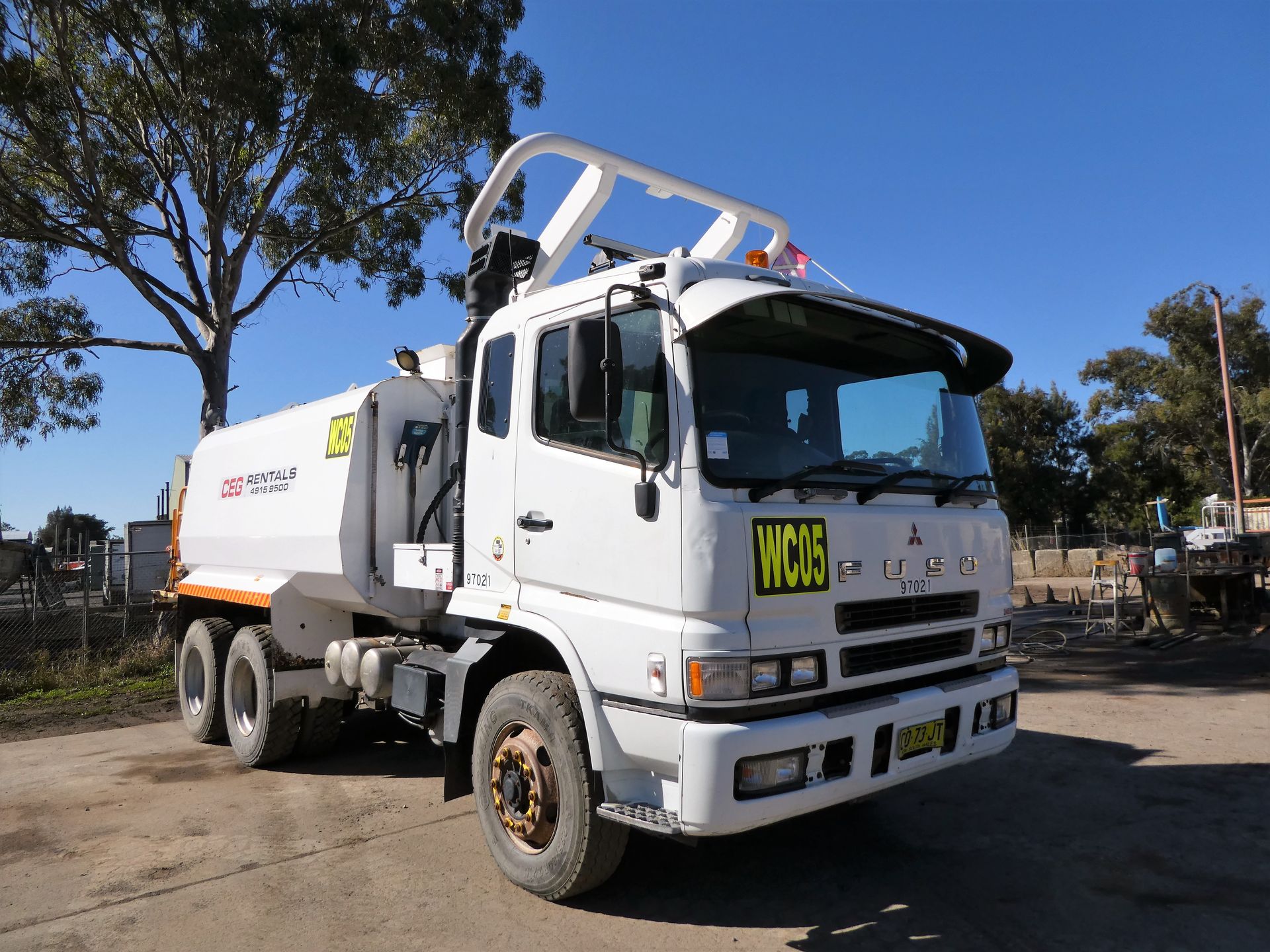 A white truck with a yellow sign on the front that says 1106
