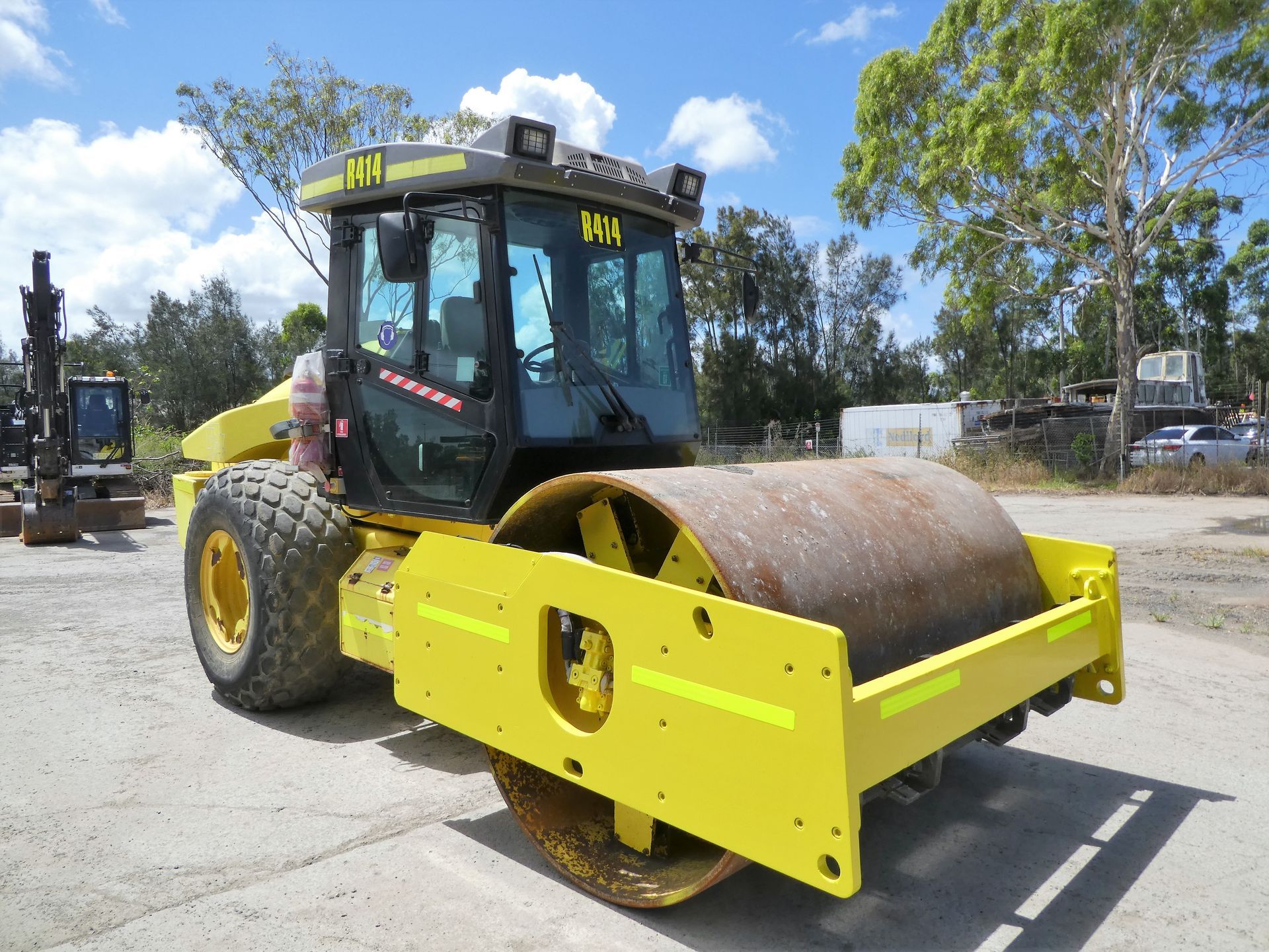 A yellow and black tractor with the letters hm on the front