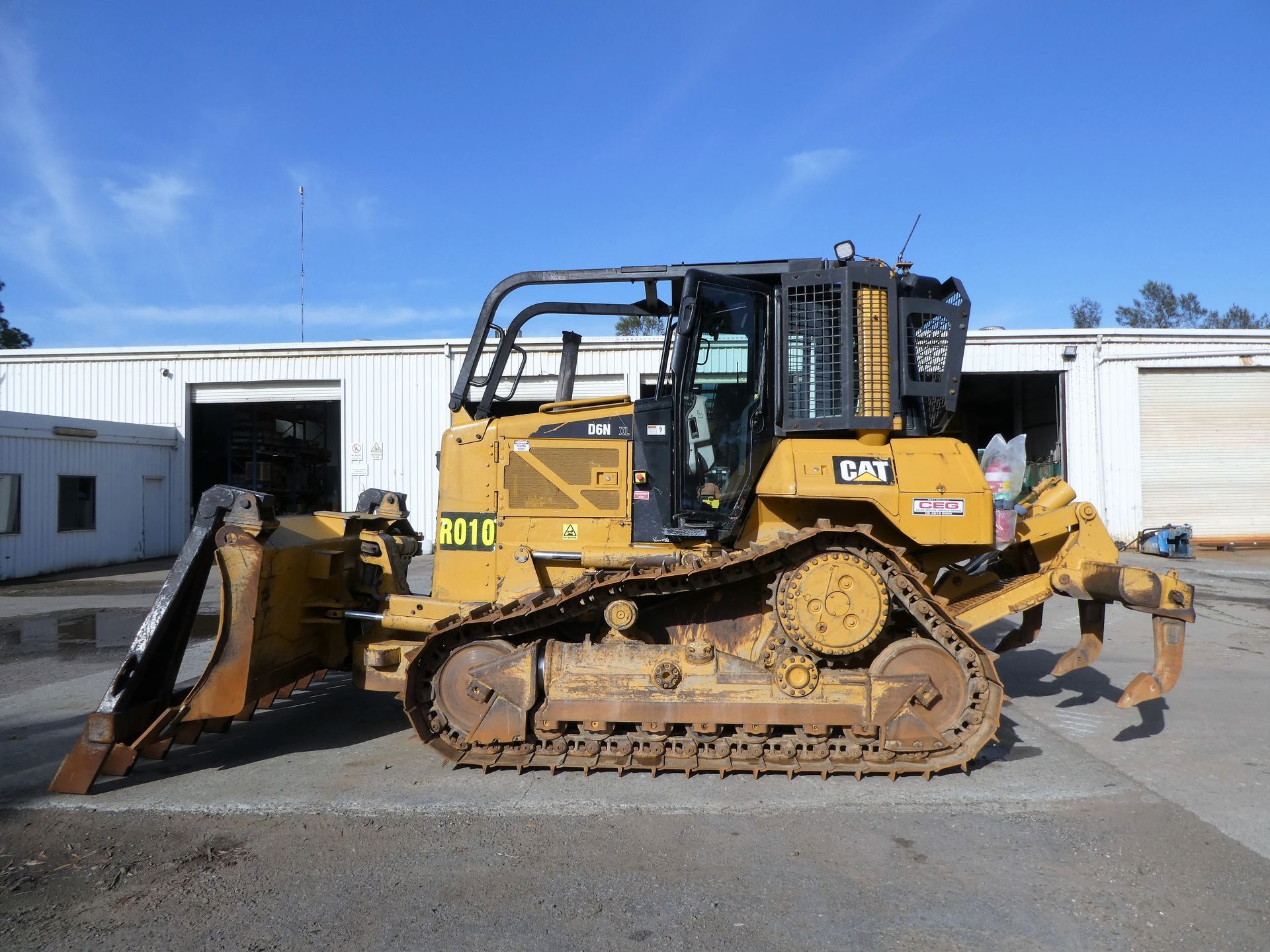 A bulldozer is parked in a parking lot in front of a building.