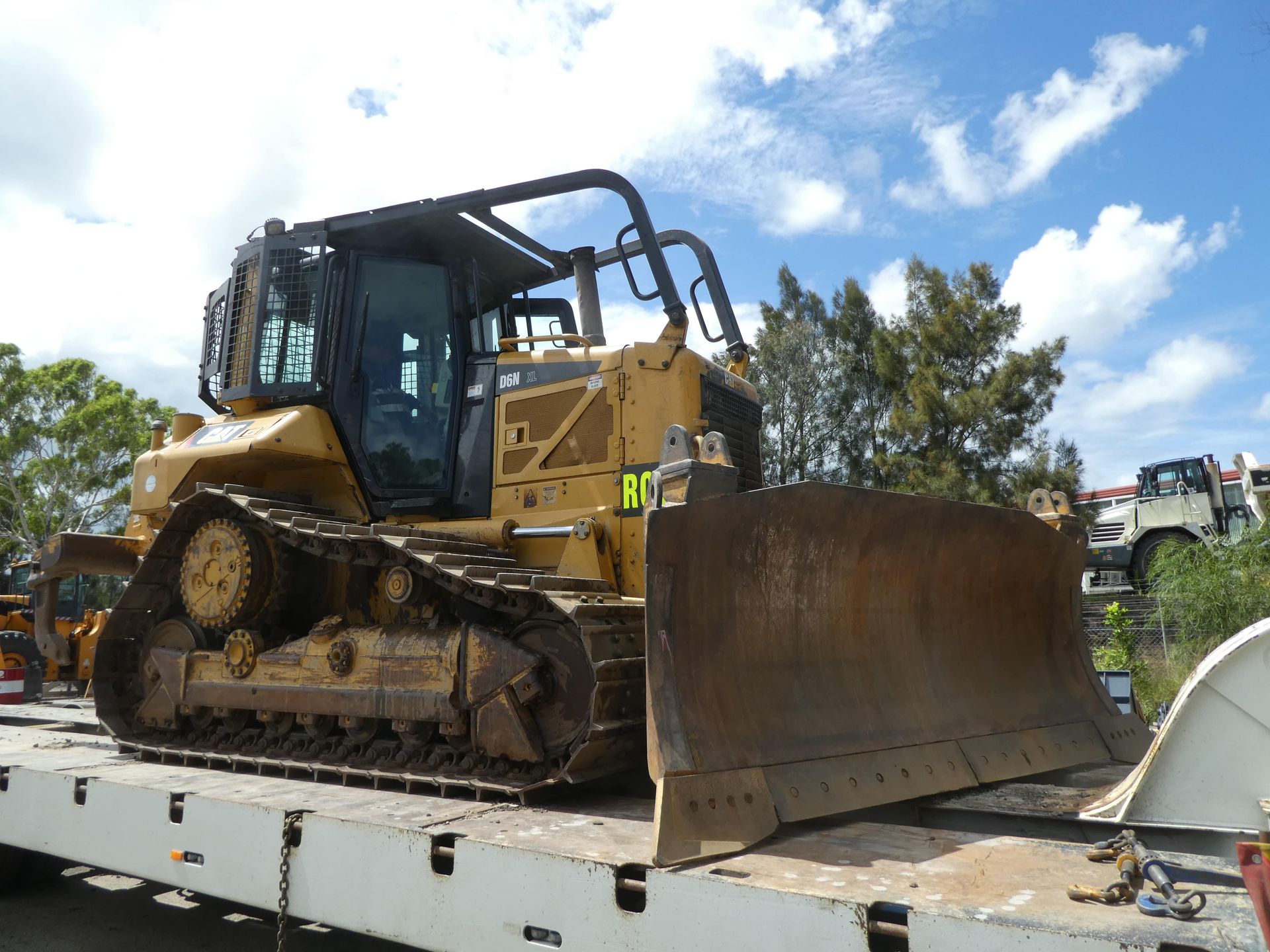 A bulldozer is sitting on top of a trailer.