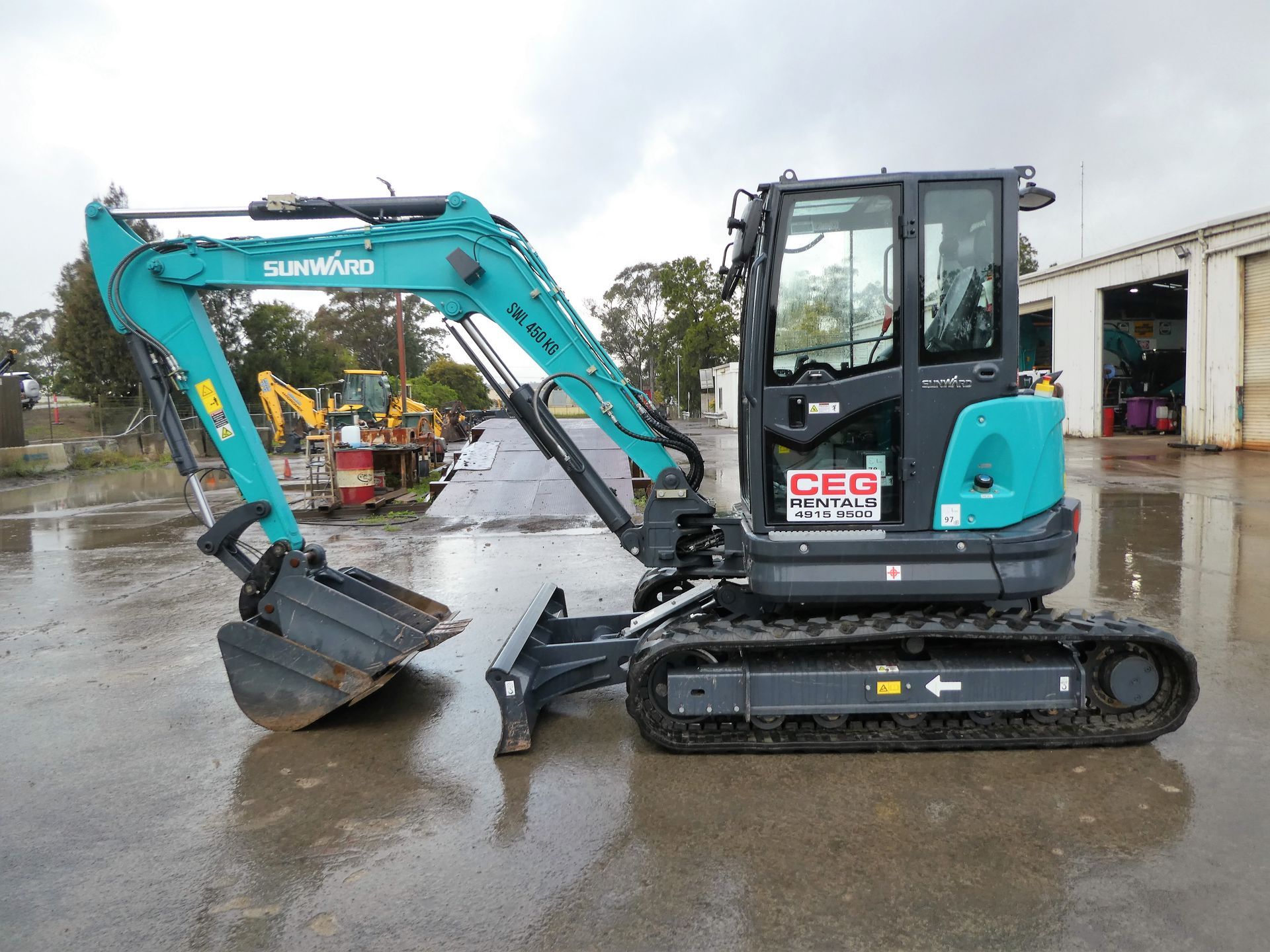 A small excavator is parked in a parking lot.
