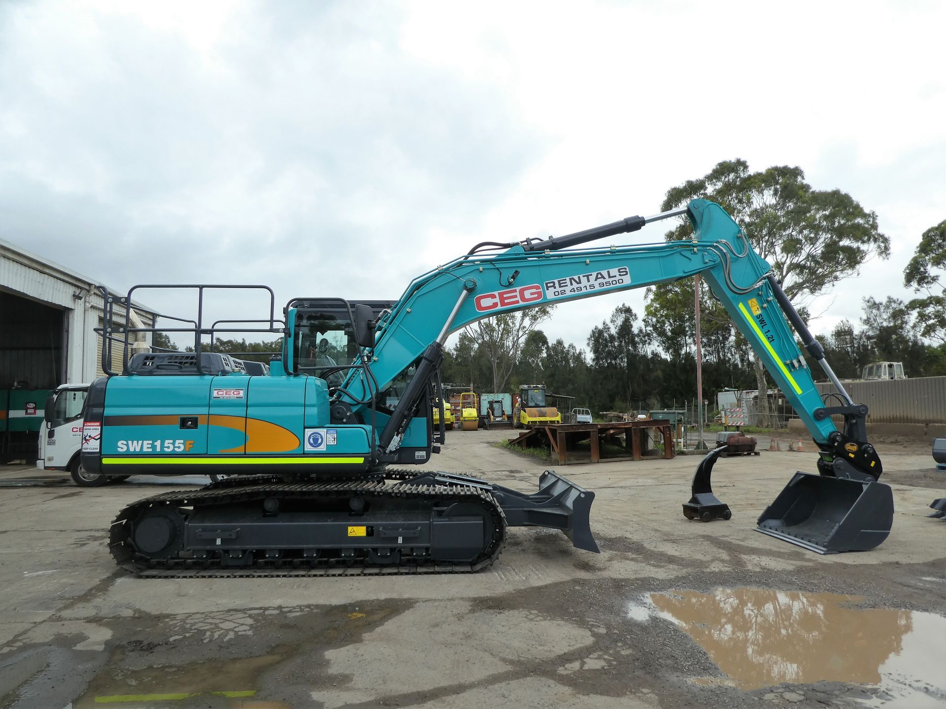 A large blue excavator is parked in a parking lot.
