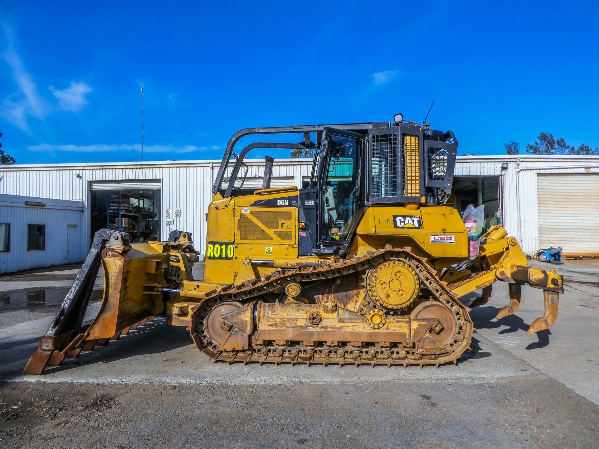 A yellow bulldozer is parked in front of a building.