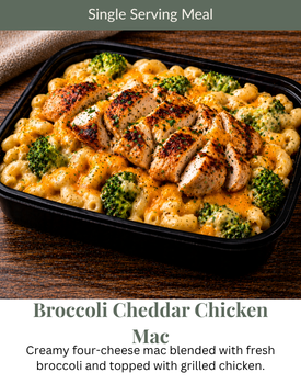 A black container of Broccoli Cheddar Chicken Mac, featuring creamy macaroni, broccoli florets, and sliced grilled chicken.
