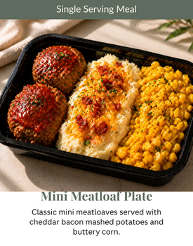 Single-serving meatloaf plate with mashed potatoes and corn in a black tray