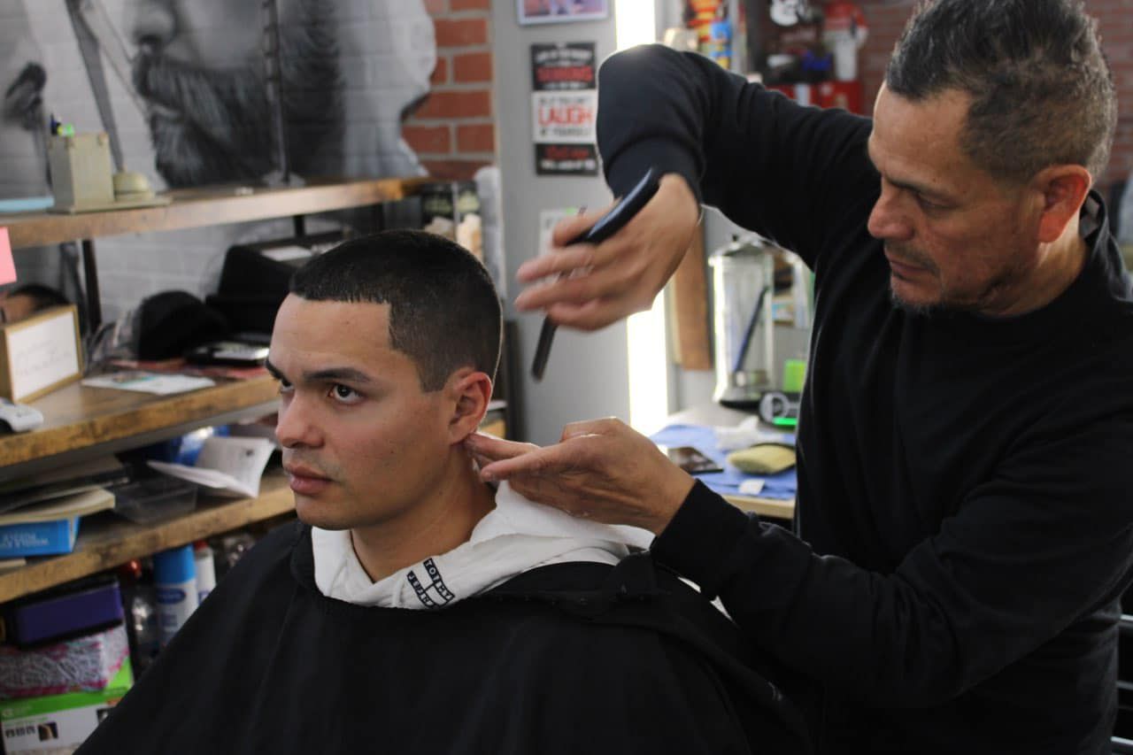 A man is getting his hair cut by a barber