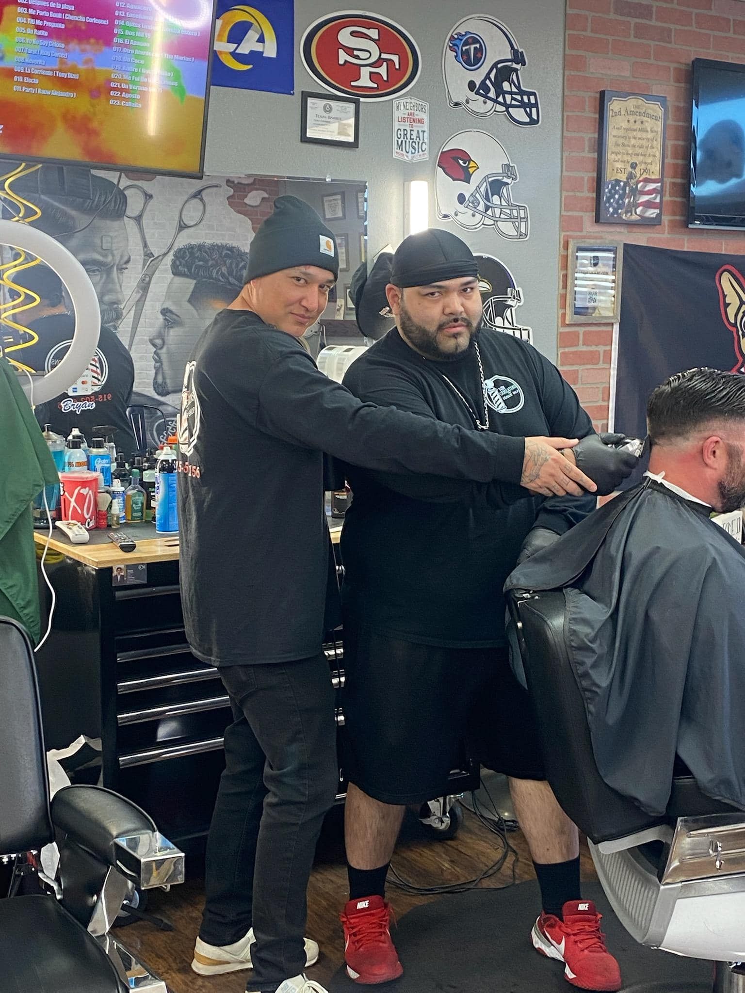 Two men are standing next to each other in a barber shop.