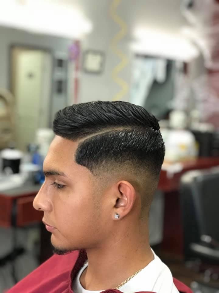 A man is getting his hair cut at a barber shop.