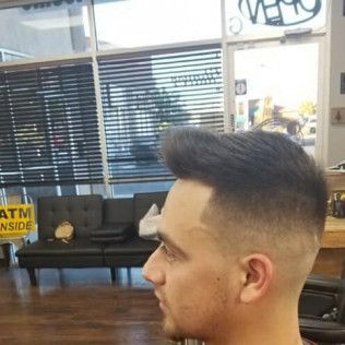 A man is getting his hair cut at a barber shop.