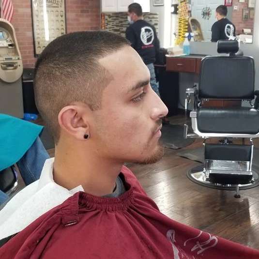 A man is getting his hair cut at a barber shop