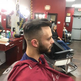 A man is getting his hair cut at a barber shop.
