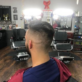 A man is getting his hair cut at a barber shop.