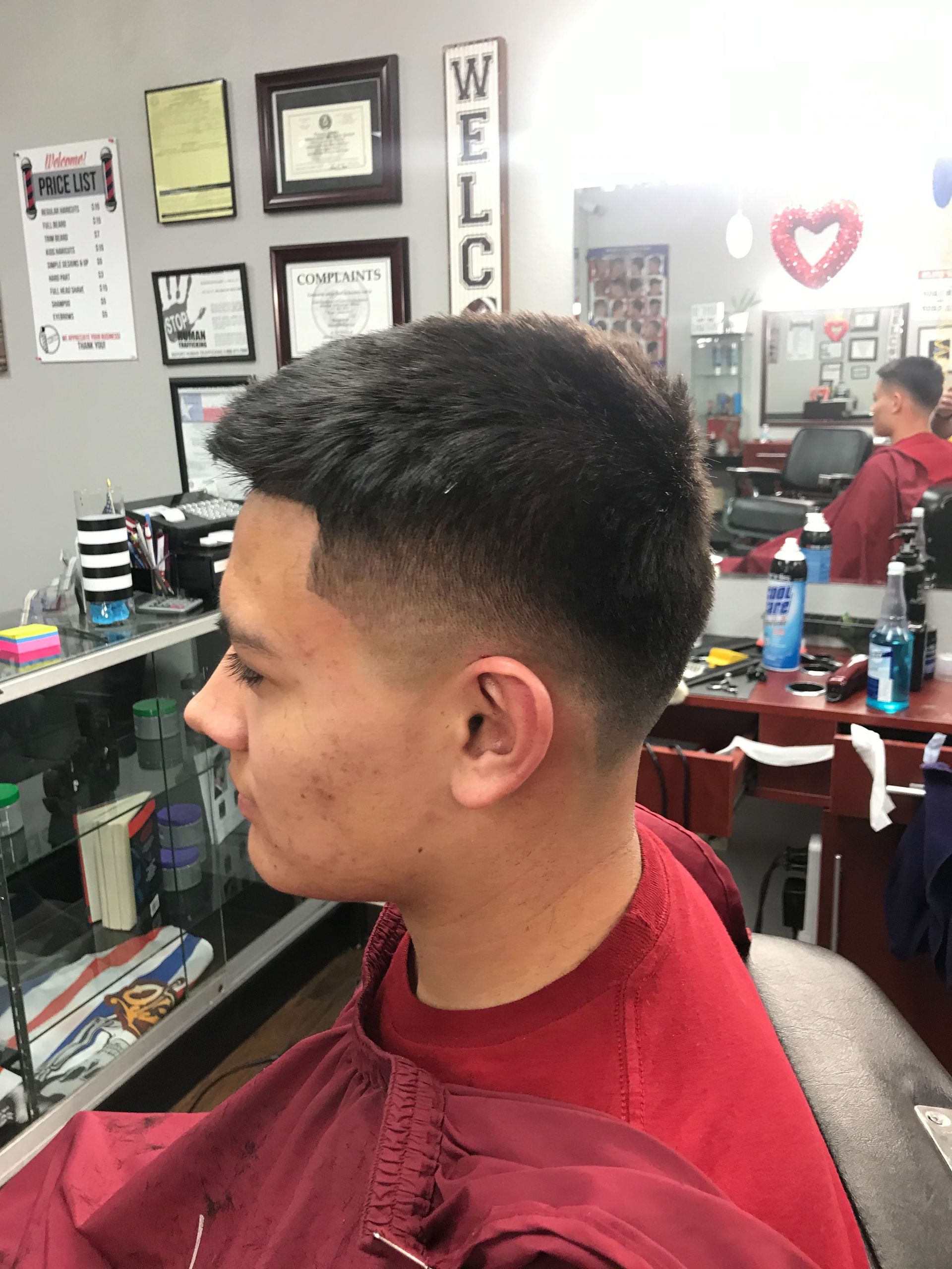 A man is getting his hair cut at a barber shop.